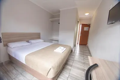 a bedroom with a bed and a television in it at Ecomotel O.R.Tambo in Kempton Park