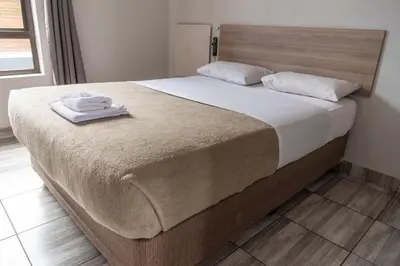 a bed with two towels sitting on top of it at Ecomotel O.R.Tambo in Kempton Park
