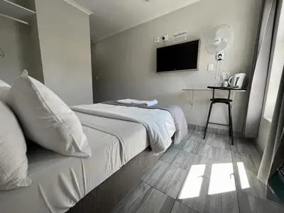 a hotel room with a bed and a television at Ecomotel Isando in Kempton Park