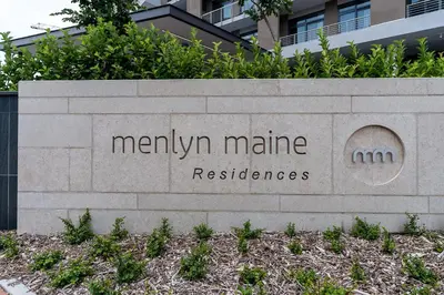 a sign in front of a building with a building at Luxurious Menlyn Maine 1 Bedroom on 12th Floor with Stunning Views & No Load Shedding in Pretoria