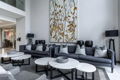 a living room with couches and tables and a painting at Luxurious Menlyn Maine 1 Bedroom on 12th Floor with Stunning Views & No Load Shedding in Pretoria