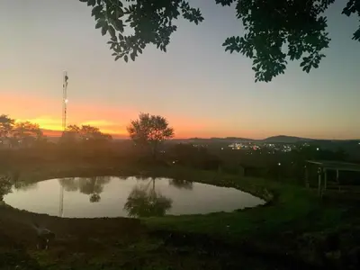 a small pond with a sunset in the background at Hazyview Accommodation, Bon Repose Cottage 2 in Hazyview