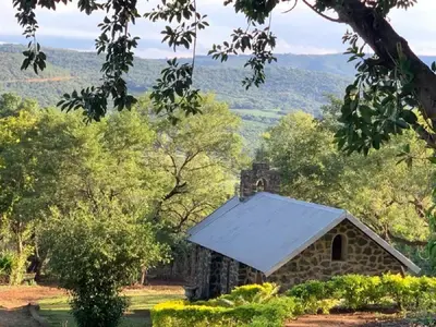 an old stone building with a white roof at Hazyview Accommodation, Bon Repose Cottage 1 in Hazyview