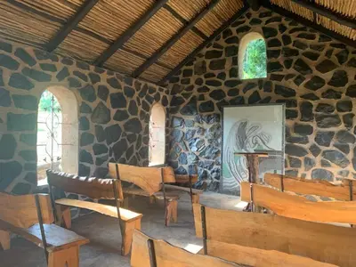 a room with wooden chairs and a stone wall at Hazyview Accommodation, Bon Repose Cottage 1 in Hazyview