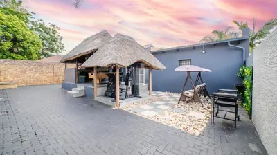 a blue building with a thatch roof at Homes of Ace Gold in Pretoria