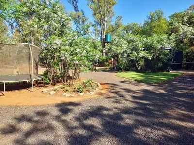 a garden with a tent and trees and grass at Vulture's View 8 in Hartbeespoort