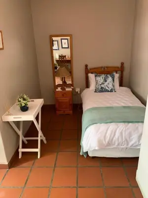 a bedroom with a bed and a table with a mirror at Barnyard Venue in Ermelo
