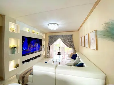 a living room with a white couch and a flat screen tv at Siena Sun Luxury Suites in Erand