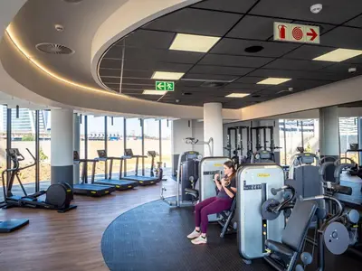 a woman sitting on a treadmill in a gym at Upmarket Executive Luxury Apartment in Midrand