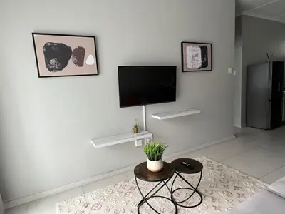 a living room with a flat screen tv on a wall at Mellow-Suites Apartments - 31 - WIFI and Netflix in Midrand