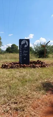 a sign sitting in the middle of a field at Hartbees Bush Stay #1 in Hartbeespoort