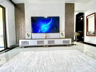 a living room with a flat screen tv on a wall at Siena Sun Luxury Suites 2 in Midrand