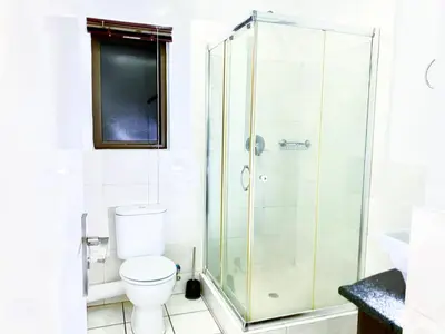 a bathroom with a shower and a toilet at Siena Sun Luxury Suites 2 in Midrand
