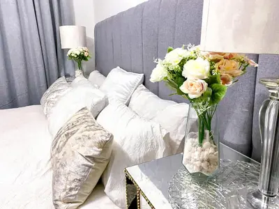 a bedroom with a bed with a vase of flowers on a table at Siena Sun Luxury Suites 5 in Midrand