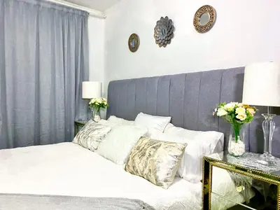 a bed with white sheets and pillows in a bedroom at Midrand Siena Sun Luxury Suites 3 with water reserve in Midrand