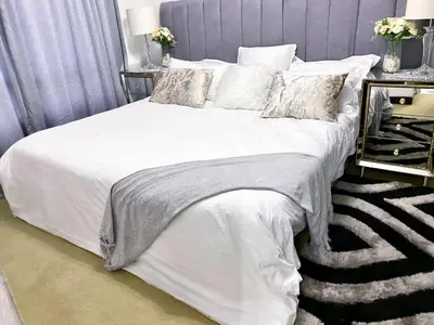 a bedroom with a bed with white sheets and pillows at Midrand Siena Sun Luxury Suites 3 with water reserve in Midrand