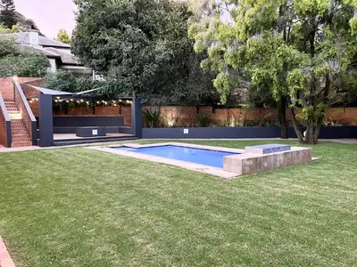 a backyard with a swimming pool in the grass at Afrique134 Willow Tree Private Garden Suite in Pretoria